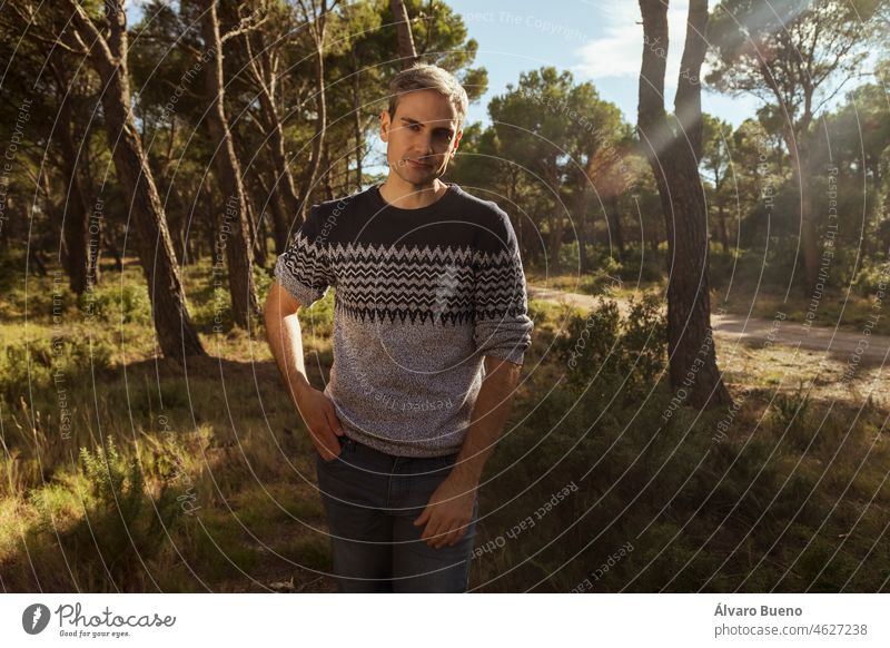 A young man in his 30s with gray hair walks through a forest in and enjoys a healthy lifestyle, Aragon, Spain adult race white Caucasian jersey dress jeans