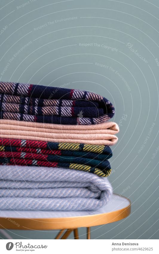 Stack of woolen checked blankets winter warm home comfort autumn comfortable soft nobody living sofa indoors living room interior house folded textile knitted