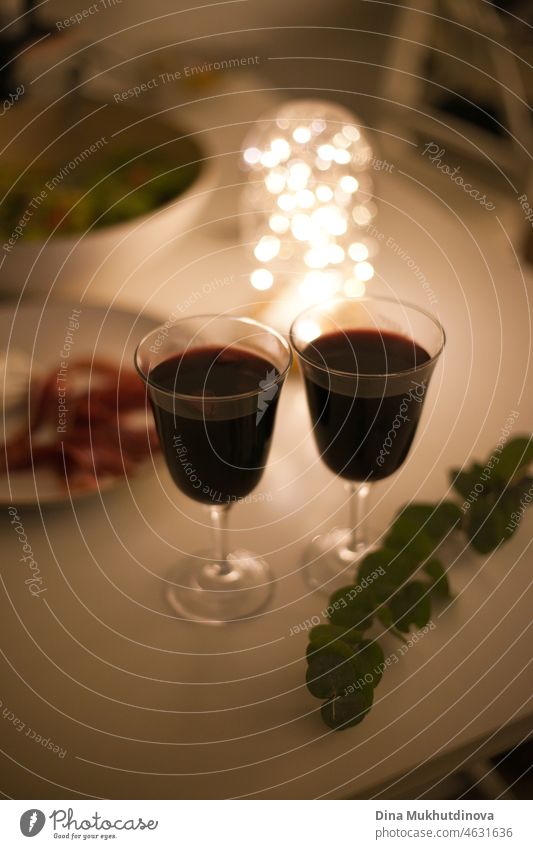 https://www.photocase.com/photos/4631636-two-glasses-of-red-wine-with-appetizers-on-a-romantic-candlelight-date-with-festive-lights-photocase-stock-photo-large.jpeg