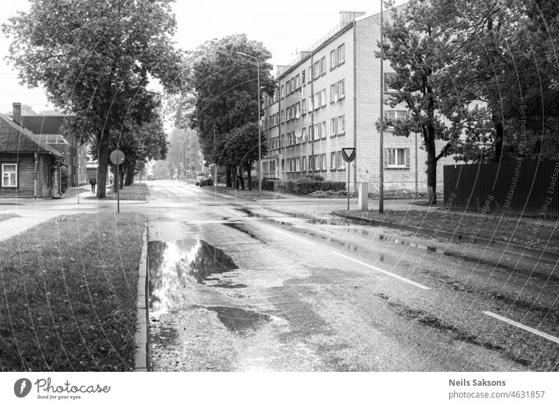 street in rainy day in town. Houses, puddles, people walking architecture autumn black black and white building building exterior city cityscape cold europe