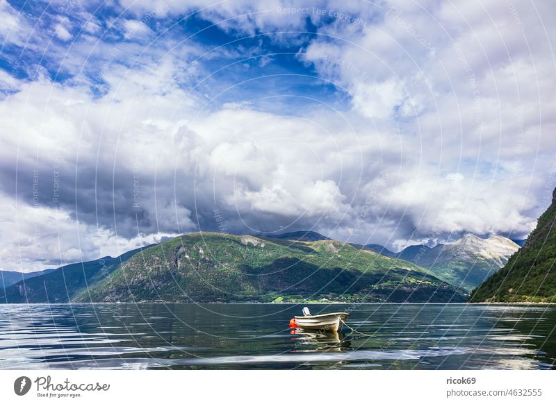 A boat on the Storfjord in Norway Fjord North Dal Scandinavia mountain mountains Landscape Nature Water Summer Sunnmore More og Romsdal Clouds Sky Blue Green