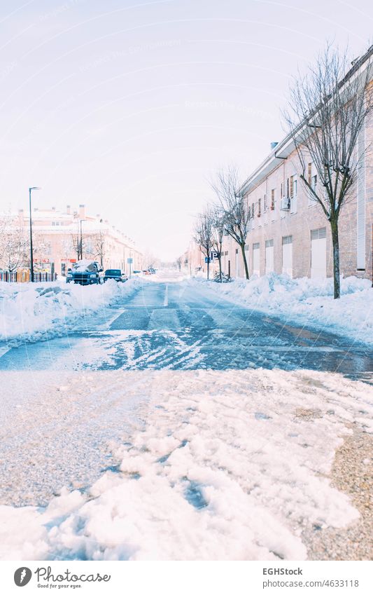 Street full of ice after a heavy snowfall with cars buried under the snow. Winter season. Focus on road auto automobile blizzard city climate cold condition