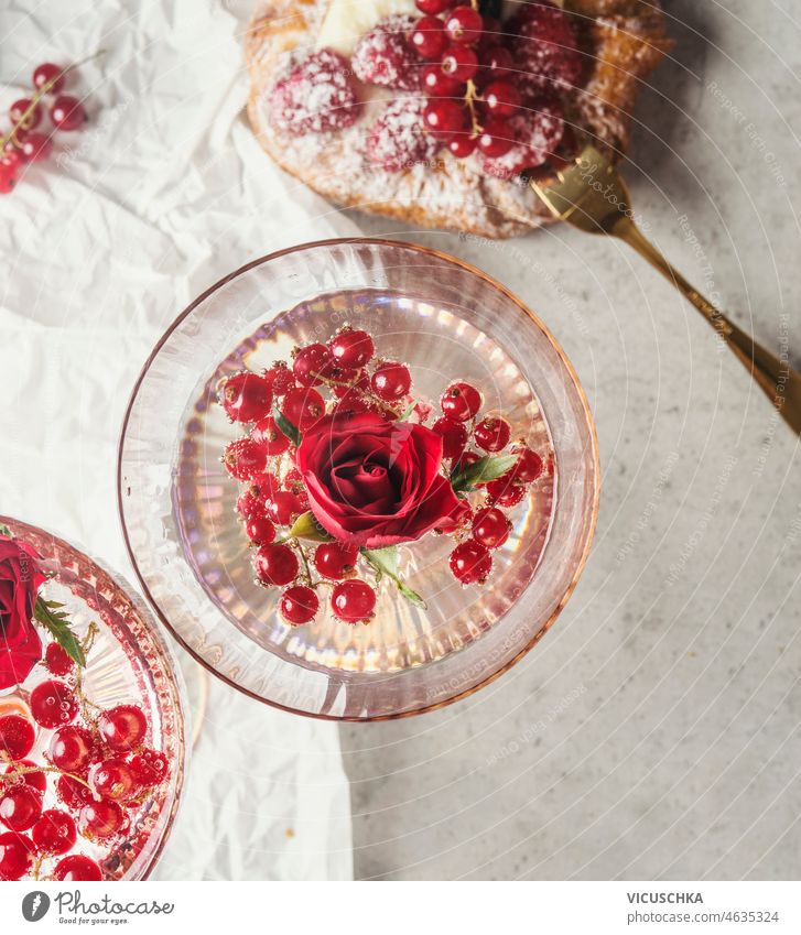 Champagne glass with rose petal and red currants on white background with berry tart. champagne food drink concept fruits sweet dessert top view alcohol