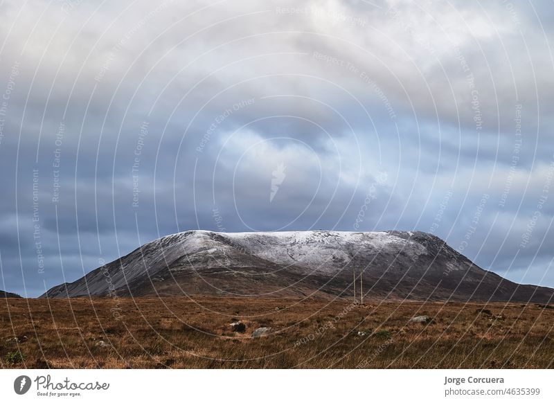 Errigal mountain. County Donegal. snowy peak in winter with cloudy sky and beautiful colors errigal scenery highest travel park rural tranquil water isolated