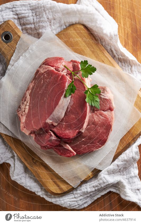 Raw beef sirloins on cutting board fillet meat kitchen raw food culinary cuisine uncooked herb parchment prepare slice recipe chopping board table product