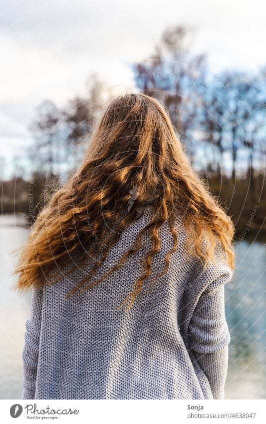 Back view of young woman with long curly hair Long-haired Curly Brunette Woman youthful Rear view Lakeside Winter pretty Feminine Adults Hair and hairstyles