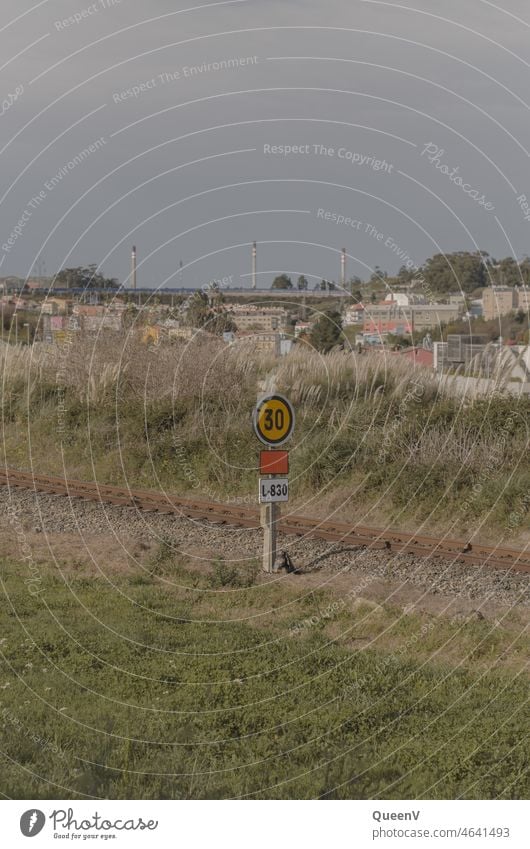 Railroad with traffic signs and refinery and apartments in the background Refinery by rail Train Transport Traffic infrastructure Means of transport