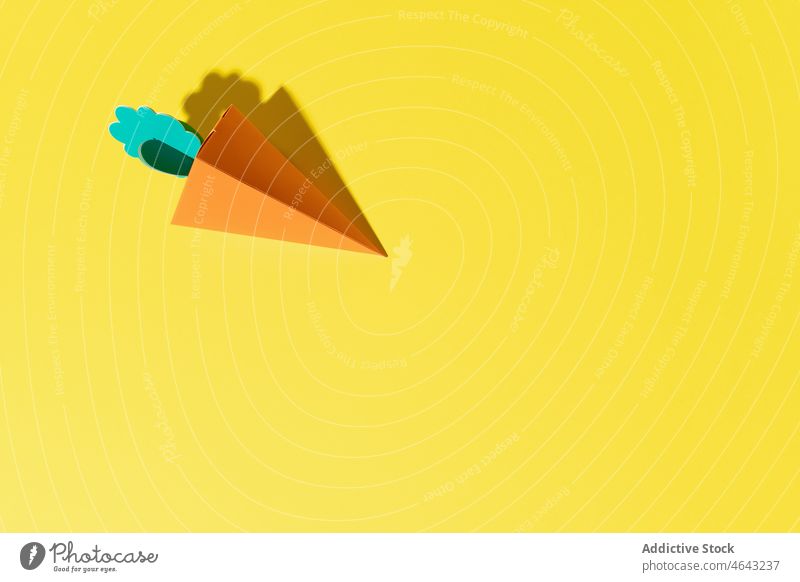 Cardboard carrot on a yellow background in daylight food green healthy vegetarian design leaf nature beautiful fresh white concept nutrition orange vegan ripe