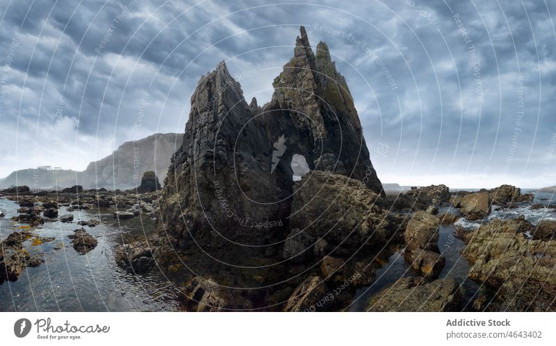 Campiecho beach with rocky cliffs sea water coast nature boulder campiecho stone asturias spain formation shore rough cloudy overcast environment scenery