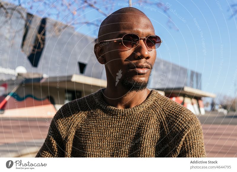 Stylish black man in sunglasses on street fashion style appearance design trendy outfit city serious male bald confident african american eyewear unshaven guy