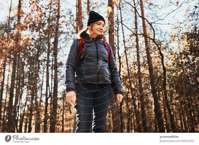 Woman enjoying hike on sunny vacation day. Female with backpack walking through forest path trip hiking adventure travel summer journey wanderlust hiker