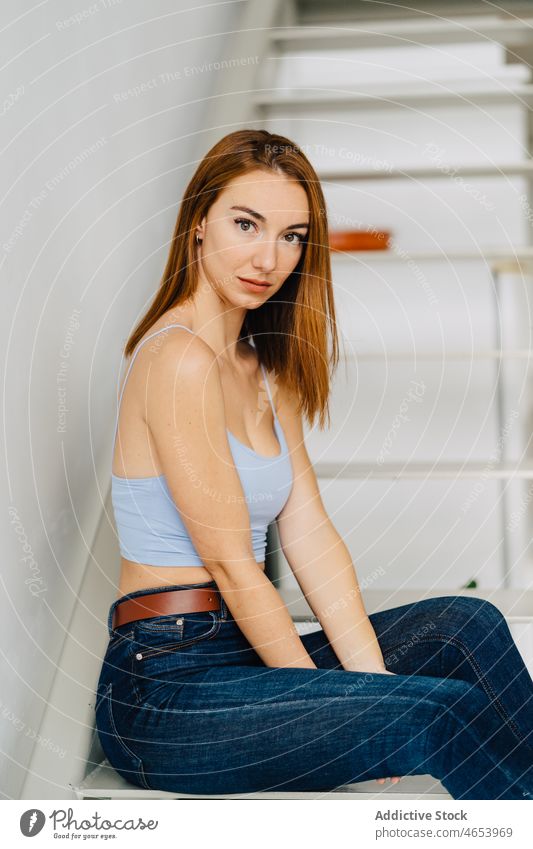 Attractive redhead woman on stairs appearance individuality style outfit wear personality stairway female young slim sensual bare shoulders top feminine glamour