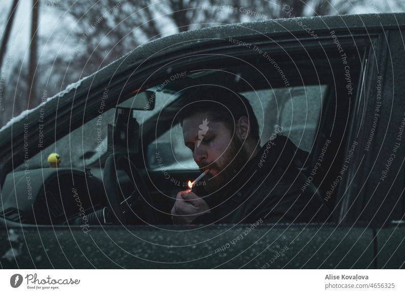 man lighting a cigarette in a car portrait Cigarette Lighting a cigarette In a car Nicotine Smoking Unhealthy Smoke Winter snow Filter-tipped cigarette fire