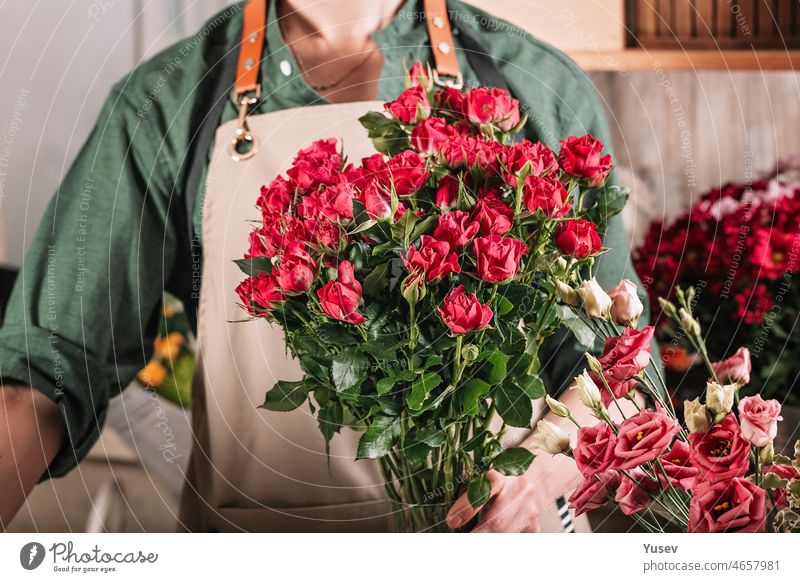 Florist make gift bouquets in hat boxes. Graceful female hands make a  beautiful bouquet. Florist workplace. Small business concept. Front view.  Flowers and accessories - a Royalty Free Stock Photo from Photocase