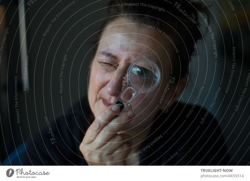 "Is there not a hair in the soup either?"  The critical eye of a lady looks through a magnifying glass Face of a woman Woman`s head portrait of a woman Adults