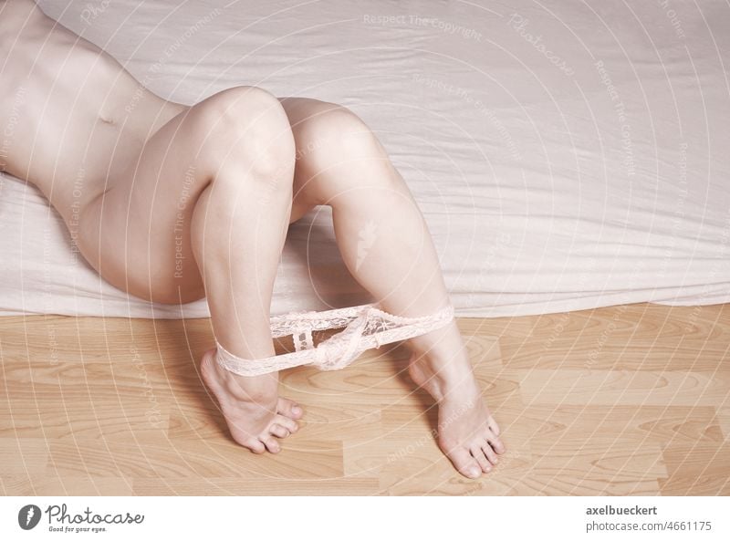 naked woman lying on bed with panties around her ankles - a Royalty Free  Stock Photo from Photocase