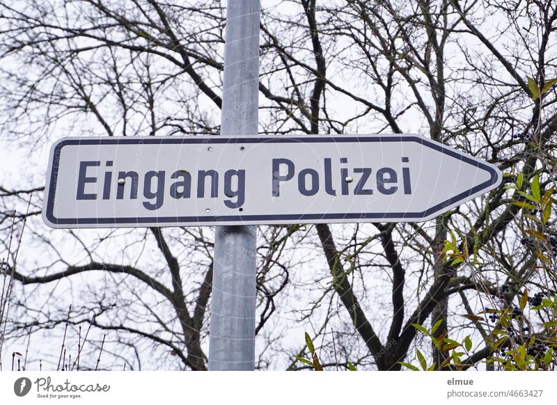 Sign / signpost - entrance police - on a metal pipe in front of bare trees Signage Police Force Police Station Agency State Police Road marking Politeia