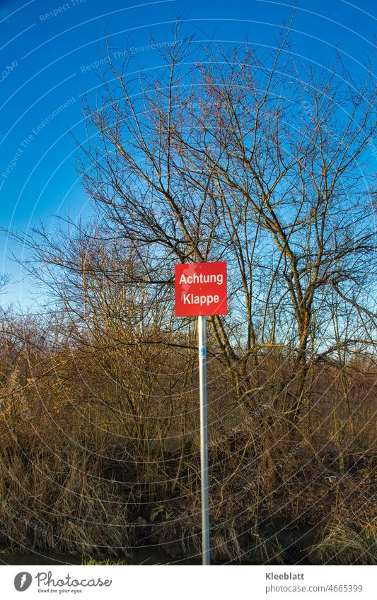 Red warning sign with inscription - Attention flap - in the wild at a hidden creek esteem Flap Signs and labeling Warning label Warning sign Signage Caution