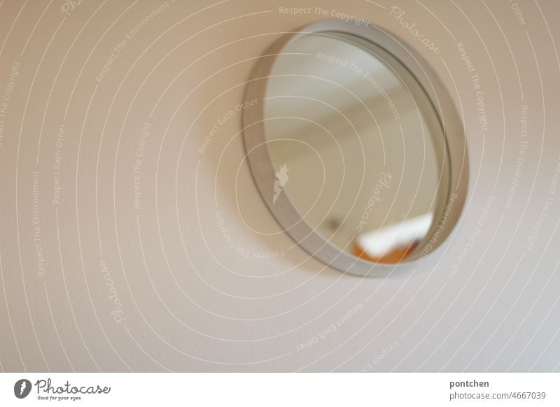 A round vintage mirror hangs on a white wall. Home furnishings Mirror Round Wall (building) '60s 1970s White unostentatious Design Style Living or residing