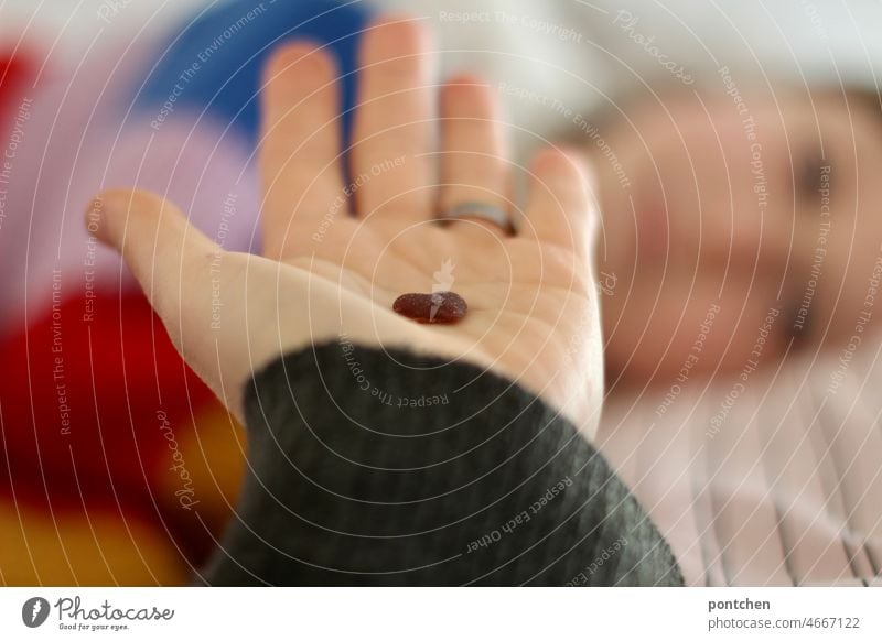 Mother love, parent love. Symbol image. A hand holds a small heart towards a child lying down. Illness, nurse Love Heart Motherly love parental love Child