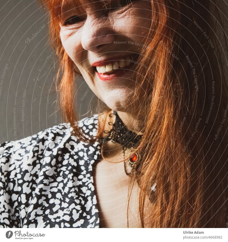 Laughter is good for you - woman with red long hair, laughs heartily into camera Looking into the camera Optimism Authentic Friendliness Contentment Woman