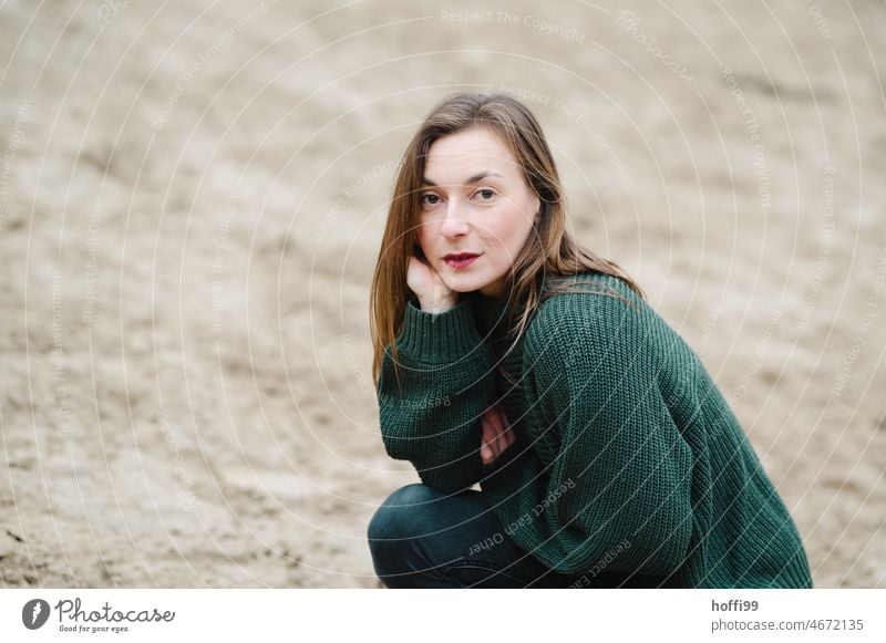 the woman looks contemplatively smiling into the camera smiling woman Pensive Face of a woman smilingly Looking into the camera Feminine Self-confident