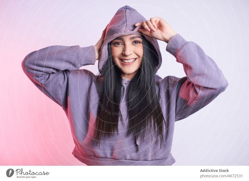 Positive woman in casual outfit portrait smile appearance positive hoodie cheerful happy glad young trendy optimist long hair attire joy content studio delight