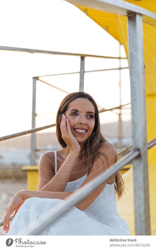 Happy woman resting near lifeguard tower summer happy seaside traveler beach holiday enjoy female young vacation cheerful relax smile carefree station cabin