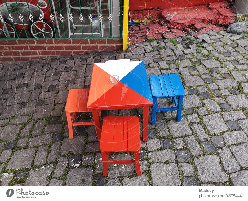 Colorful stools with table on old cobblestones in front of a bistro, teahouse and café in summer in the alleys of the old town of Bursa in Turkey Still Life