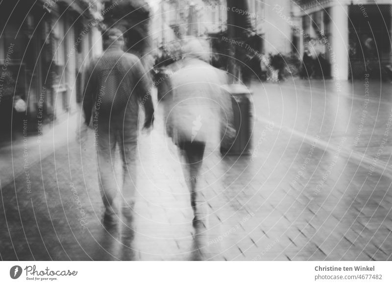 Walk through the city after the rain Couple To go for a walk Town Pedestrian precinct city stroll blurred Reflection Wet Shadow Street 2 people Lübeck Going
