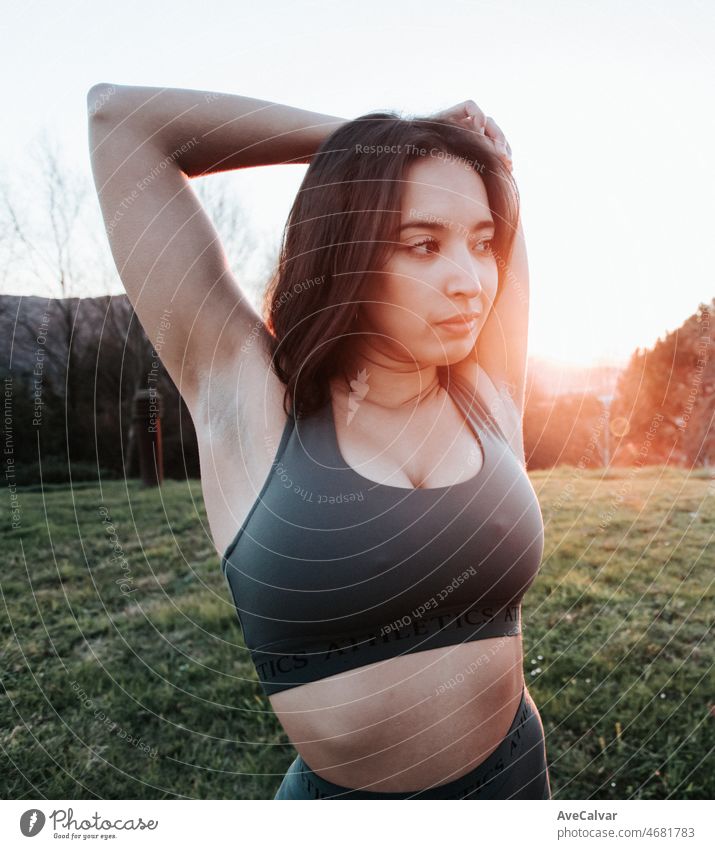 Portrait of a young woman stretching arms during a training session to lose  weight on a sunset. Training new sports concept. - a Royalty Free Stock  Photo from Photocase