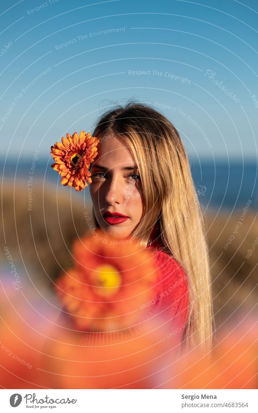 Artistic portrait of a caucasian woman with orange flowers and blue sky Sky photo art Young woman Woman Model Flower outdoor pretty cute long hair face fun