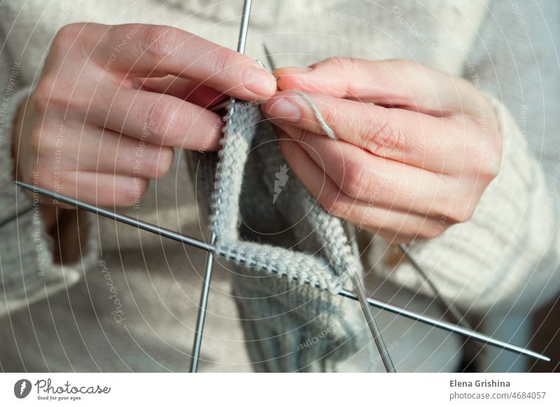 Female hands hold knitting needles and knit a sock. Handmade and hobby concept. knitter woman craft homemade wool yarn handmade female woolen finger work socks