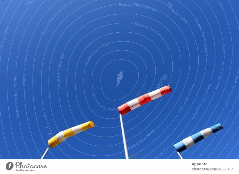 Three windsocks yellow-red-blue in front of bright blue sky tornado Gale Sky Wind direction Display Weather prediction Synchronous Exterior shot Yellow Red Blue