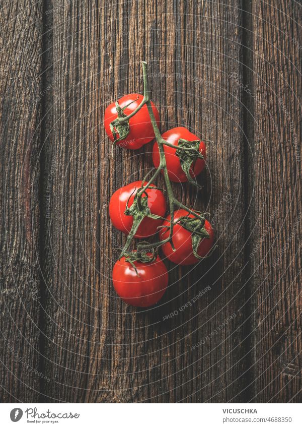 Close up of red tomatoes on dark rustic wooden background. close up seasonal healthy summer vegetable top view cherry tomatoes closeup cooking delicious food