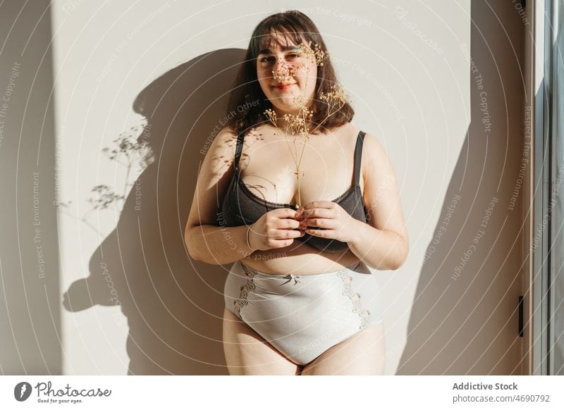 thick woman in lingerie lying at sunlight on fur laughing Stock Photo