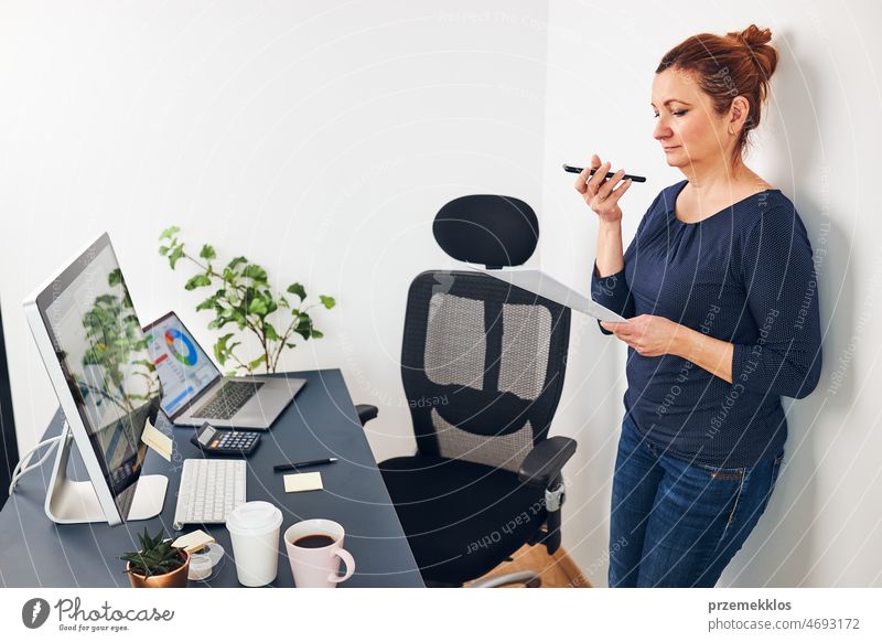Woman entrepreneur having business  conversation on mobile phone. Businesswoman working in office holding documents and smartphone call calling graph chart