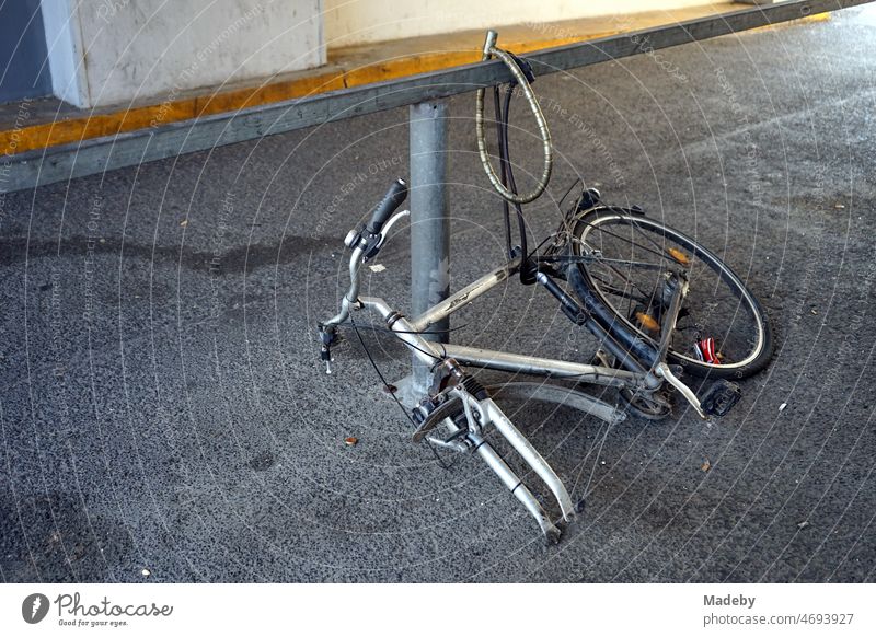 Remains of a locked bicycle without front wheel in a gray passageway in Hanauer Landstraße in the Ostend district of Frankfurt am Main in the German state of Hesse