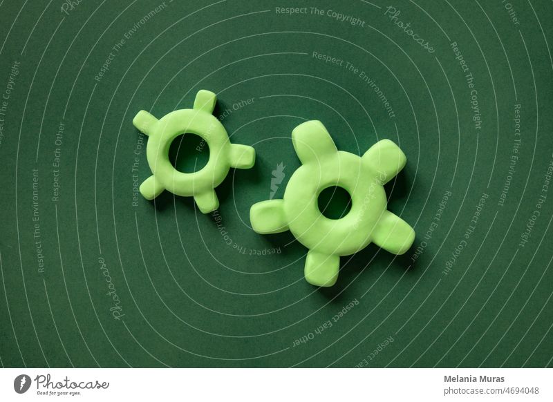 Two 3d gears of different sizes on a green background. Mechanism elements, concept of progress, teamwork. brainstorming business cog cogwheel collaboration