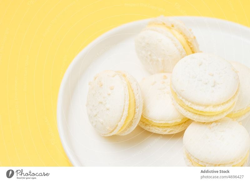 Pile of vanilla macarons on plate dessert sweet confection white confectionery indulge treat food flavor fresh tasty delicious yummy appetizing macaroon french