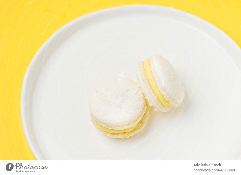 Vanilla macaroons with filling on table macaron vanilla dessert sweet confection plate dish confectionery indulge treat food flavor fresh tasty delicious yummy