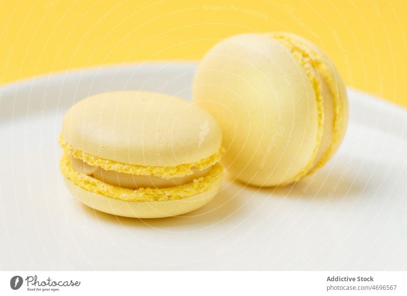 Pile of lemon macarons on plate dessert sweet confection confectionery indulge treat food flavor fresh tasty delicious yummy appetizing macaroon french bright