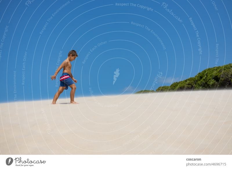 Little boy walking down a dune on a spanish beach adorable blue blue sky bolonia cadiz caribbean caucasian cheerful child childhood coastline de freedom fun