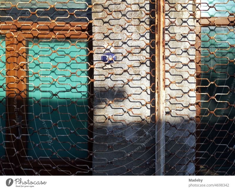 Rusty scissor grate in front of a closed store in summer sunshine in the old town of Foca on the Aegean Sea in Izmir province, Turkey Khaki Ochre Beige