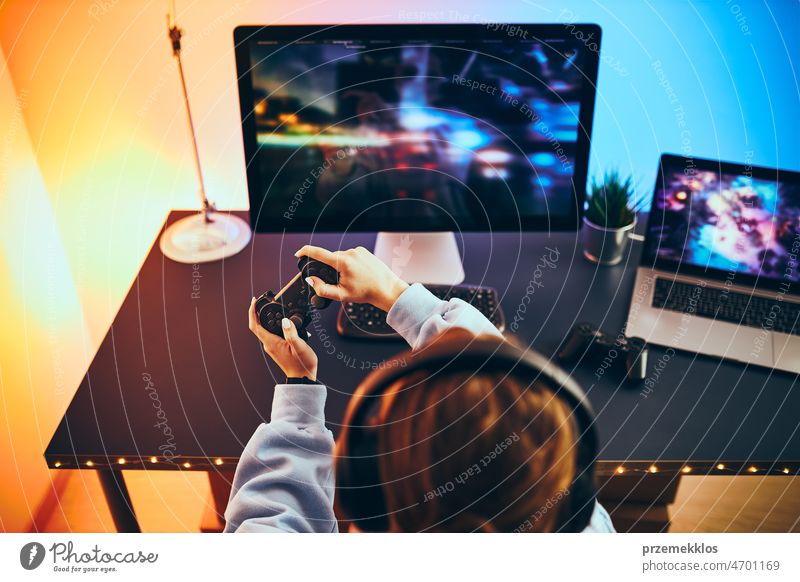 Teenager girl playing video game at home. Gamer playing online in dark room lit by neon lights. Competition and having fun gaming competition gamer technology