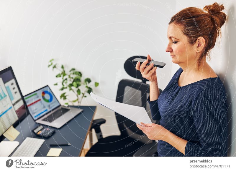 Woman entrepreneur having business  conversation on mobile phone. Businesswoman working in office holding documents and smartphone call calling graph chart