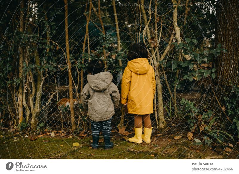 Rear view children with hooded jacket Child childhood Brothers and sisters 2 people 1 - 3 years 3 - 8 years Emotions Day Playing Together Colour photo
