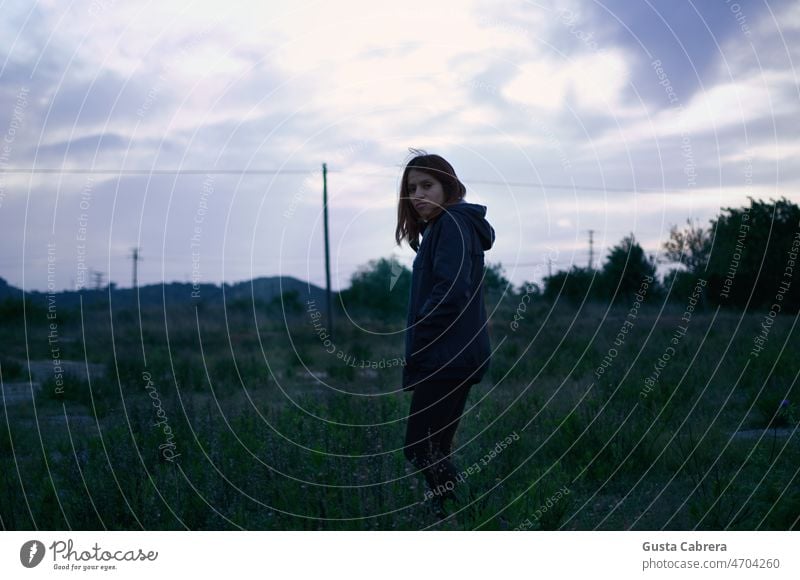 Woman walking through the field at sunset. Portrait photograph Face Looking Brunette Landscape Field Exterior shot Shallow depth of field Colour photo