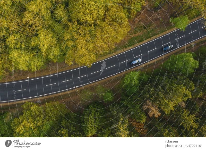 Drone view of cars driving on suburban road on background summer forest aerial drone eye curve landscape nature adventure green country asphalt grass natural