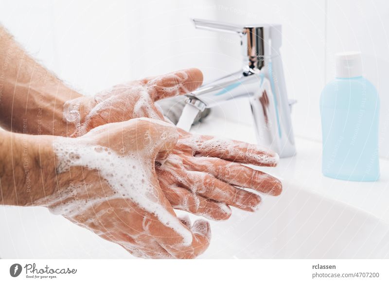 Washing hands man rinsing soap with running water at sink, Coronavirus prevention hand hygiene. Corona Virus pandemic protection by cleaning hands frequently.